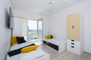 グダニスクにあるFeel Summer Vibes At 3BR Panoramic View Apartmentのベッドルーム1室(ベッド2台、大きな窓付)
