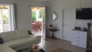 a living room with a couch and a television at Nina Villa in Rab