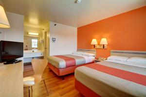 um quarto de hotel com duas camas e uma televisão de ecrã plano em Motel 6-Windsor Locks, CT - Hartford em Windsor Locks