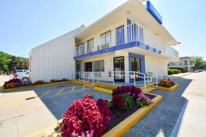a building with flowers in front of it at Motel 6-Windsor Locks, CT - Hartford in Windsor Locks