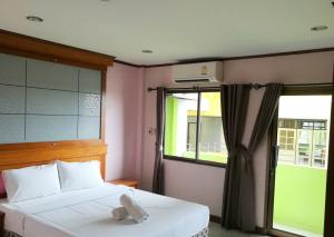 a bedroom with a bed and a window at Pongkaew Hotel in Suratthani