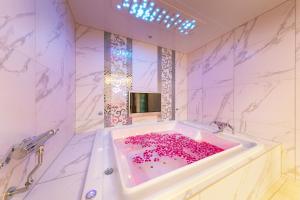 a bathroom with a tub filled with pink flowers at i RESORT ARTIA Luxury Gifu (Adult Only) in Gifu +49 photos