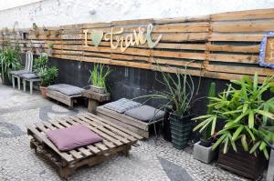 een houten muur met twee banken en planten bij Central Hostel in Rio de Janeiro