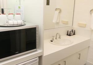 ein Badezimmer mit einem Waschbecken und einer Mikrowelle in der Unterkunft Ballina Byron Islander Resort and Conference Centre in Ballina