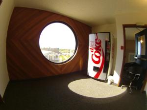 a room with a coke machine and a round window at Rycroft Hotel in Rycroft