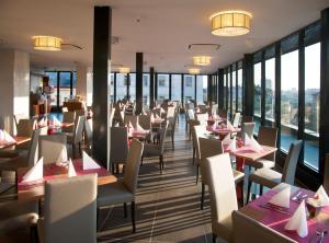 a restaurant with tables and chairs and windows at Hotel Galileo in Prague