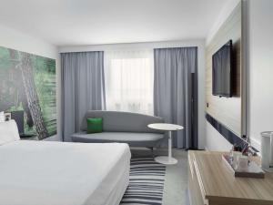 a living room filled with furniture and a window at Novotel Paris Charles de Gaulle Airport in Roissy-en-France