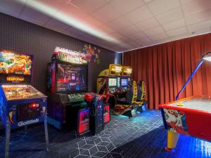 a room with two arcade games and a table at ibis Rotterdam Vlaardingen in Vlaardingen