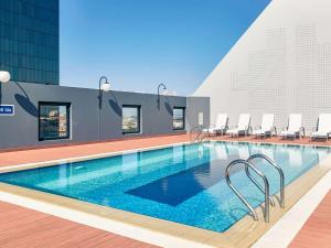 a swimming pool with a swimming pool table and chairs at Mercure Perth in Perth