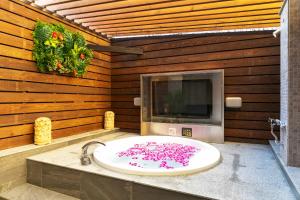 i RESORT ARTIA Luxury Gifu (Adult Only) في غيفو: حمام مع حوض وتلفزيون على الحائط