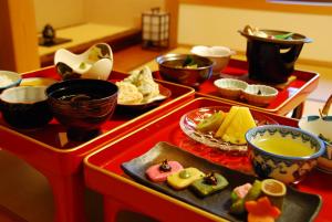 a table topped with plates of food and bowls of soup at Koyasan Shukubo Saizenin in Koyasan