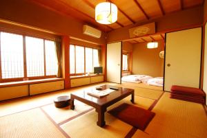 a living room with a table and a bed at Koyasan Shukubo Saizenin in Koyasan