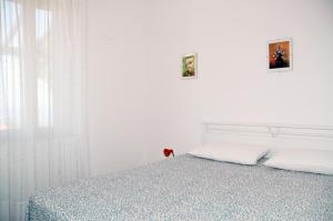 a white bedroom with a bed with two pillows at Villa Oleandro in Capoliveri
