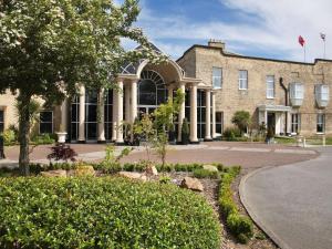 a large brick building with a tree in front of it at Mercure York Fairfield Manor Hotel in York