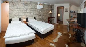 two beds in a room with a stone wall at Apartment Old Town Gverovic in Dubrovnik