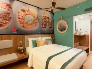 a bedroom with a bed and a painting on the wall at ibis Styles Goa Calangute - An Accor Brand in Calangute