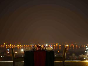 a table with wine glasses and a view of a city at Mercure Hyderabad KCP Banjara Hills, An Accor Hotel in Hyderabad