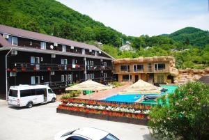 a resort with a swimming pool and a building at Ros Mari in Lazarevskoye