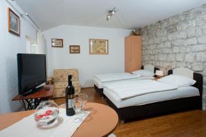 um quarto com duas camas e uma mesa com uma televisão em Apartment Old Town Gverovic em Dubrovnik