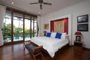 1 dormitorio con 1 cama grande con almohadas azules en Villa Padi, en Canggu