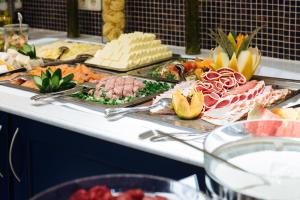 uma linha de buffet com muitos tipos diferentes de alimentos em Strandhotel Binz em Binz