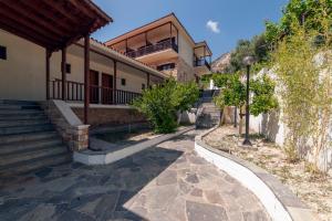 a house with stairs and a building at Corali Hotel in Kymi