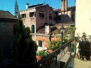 a woman standing on a balcony looking out at buildings at Hotel Città Di Milano in Venice