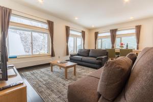 a living room with a couch and a table at Lodge Mori Apartments in Niseko
