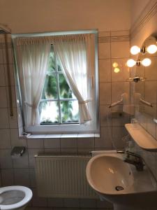 a bathroom with a sink and a window at Hotel Landhaus Köln in Lindlar