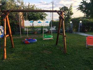 an empty swing set in the yard of a house at Latoura Studios in Ormos Panagias