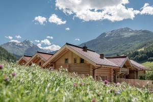 a log cabin with mountains in the background at Chalet Resort Sölden in Sölden