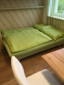 a bed in a room with a chair and a table at My apartment in Zeltweg