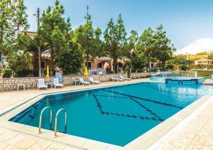 uma piscina num resort com cadeiras e árvores em Aquarella Luxury Apartment em Argasi