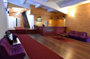 a lobby with purple couches and a red carpet at Hotel and winery LOZAR in Bitola