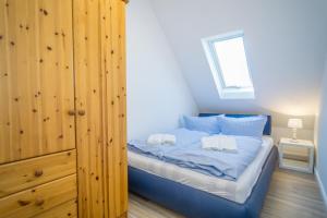 a bedroom with a blue bed with a wooden closet at Wildrose OG in Archsum