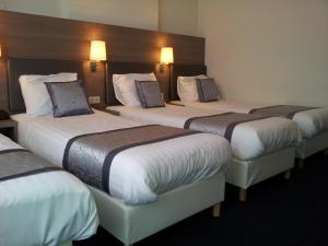 um grupo de quatro camas num quarto de hotel em The Concert Hotel em Amsterdã