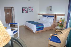 um quarto com uma cama, uma secretária e uma cadeira em Peerless Resort Port Blair em Shādipur