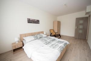 um quarto com uma cama grande e uma cadeira em Apartament Zebcowska em Ostrów Wielkopolski