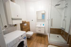 a white bathroom with a washing machine in it at Apartament Zebcowska in Ostrów Wielkopolski