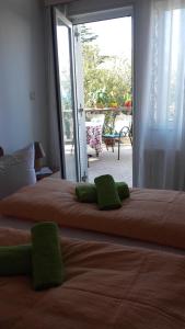 een slaapkamer met een groot bed met groene kussens erop bij Apartment Bojana in Novi Vinodolski