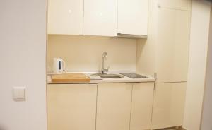 a kitchen with white cabinets and a sink at Apartamentai Druskininkuose in Druskininkai