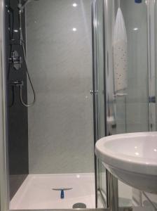 a shower with a glass door next to a sink at Dower House Newtonmore B&B in Newtonmore