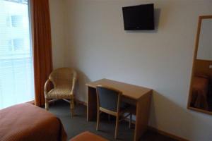 a hotel room with a desk and two chairs at Garni Cremona in Bressanone