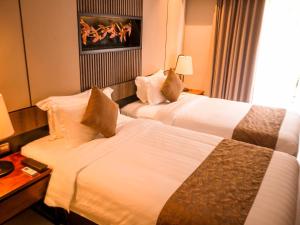 سرير أو أسرّة في غرفة في The Nest Hotel Nusa Dua