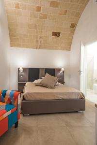 a bedroom with a bed and a brick wall at Charme B&B Dimora Quarta in Leverano