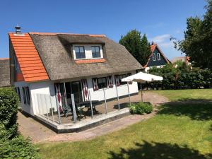 een huis met een paraplu in de tuin bij Villa Buiten 58 in Callantsoog