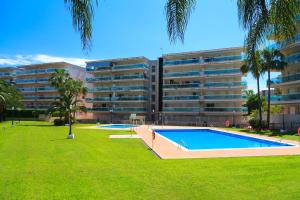 an apartment building with a swimming pool in a park at UHC Village Park Apartments in Salou