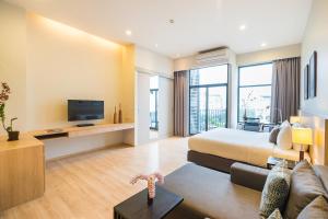 a hotel room with a bed and a tv at The Residence on Thonglor by UHG in Bangkok