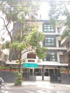 un bâtiment avec un arbre en face dans l'établissement Luxtay Suites, à Bangalore