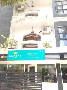 un edificio con una señal azul delante de él en Luxtay Suites, en Bangalore